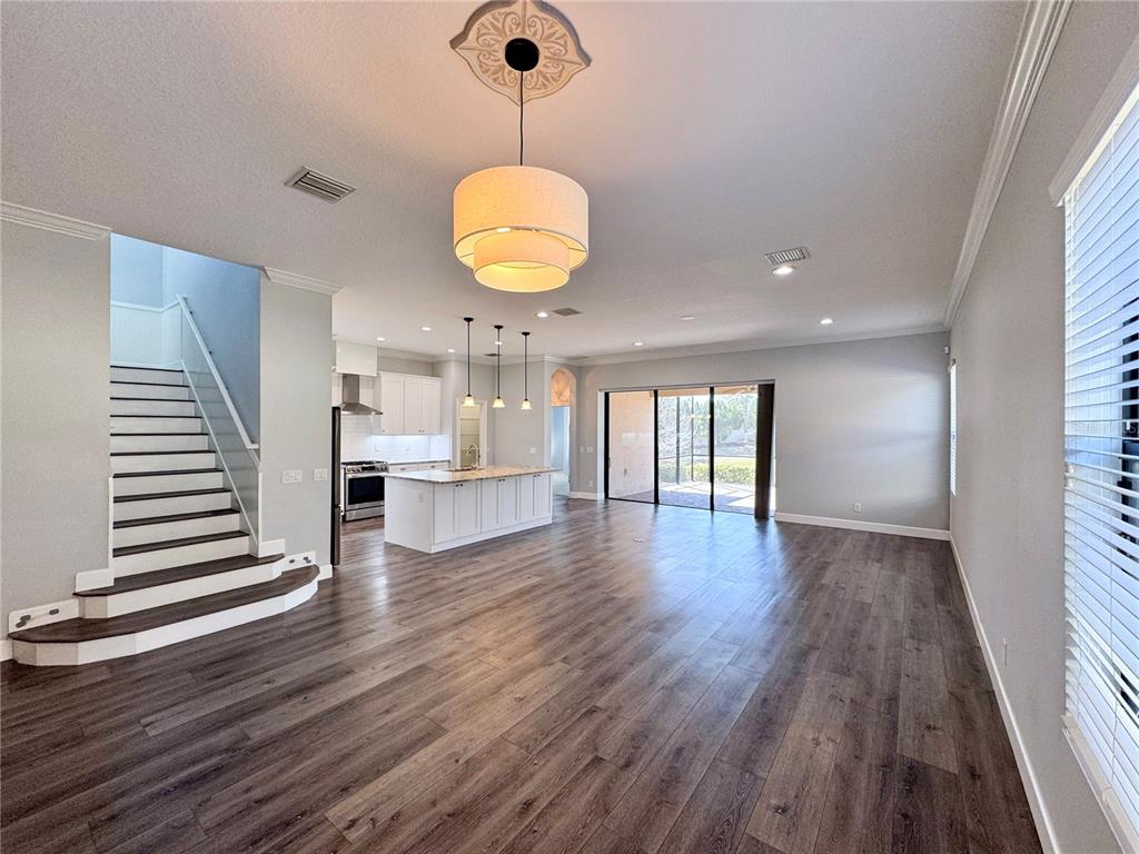 12822 Del Corso Loop Bradenton, FL 34211 - Photo 7 of 58 a view of an empty room with wooden floor and windows