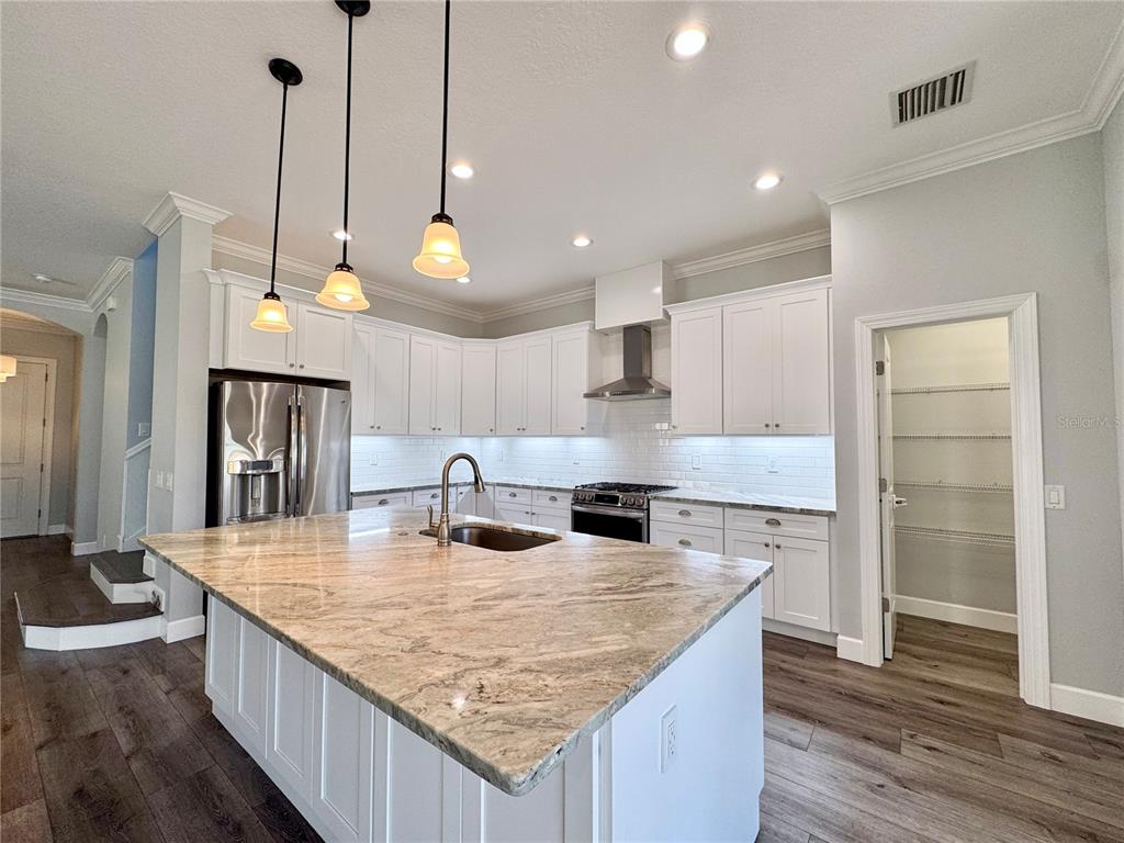 12822 Del Corso Loop Bradenton, FL 34211 - Photo 8 of 58 a kitchen with kitchen island a counter top space a sink stainless steel appliances and cabinets