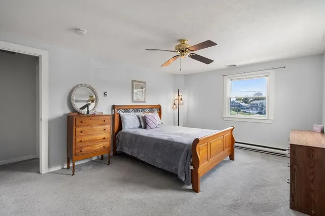 a bedroom with a bed window and dresser
