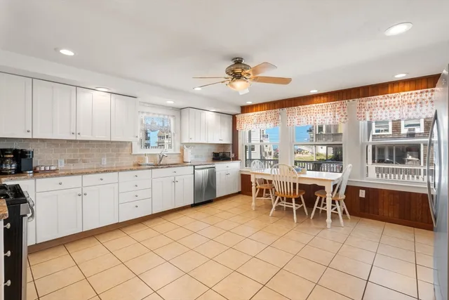 a kitchen with a dining table chairs and white appliances