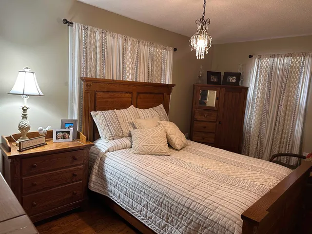 a bedroom with a bed and a chandelier