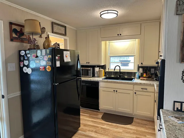 a kitchen with stainless steel appliances granite countertop a refrigerator and a sink