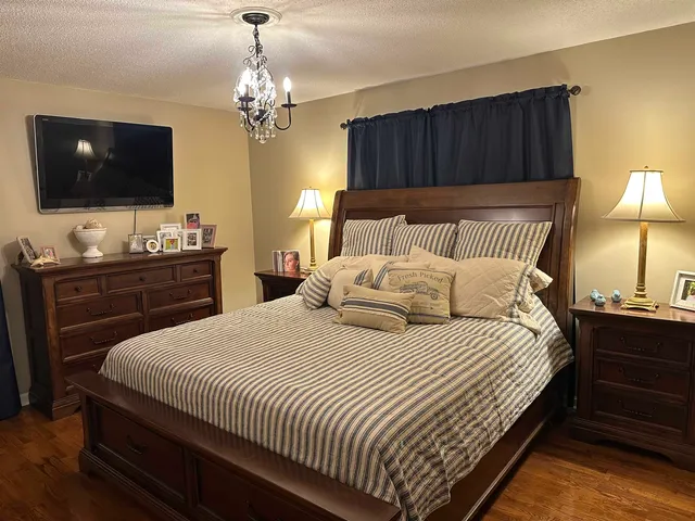 a bedroom with bed tv and a window