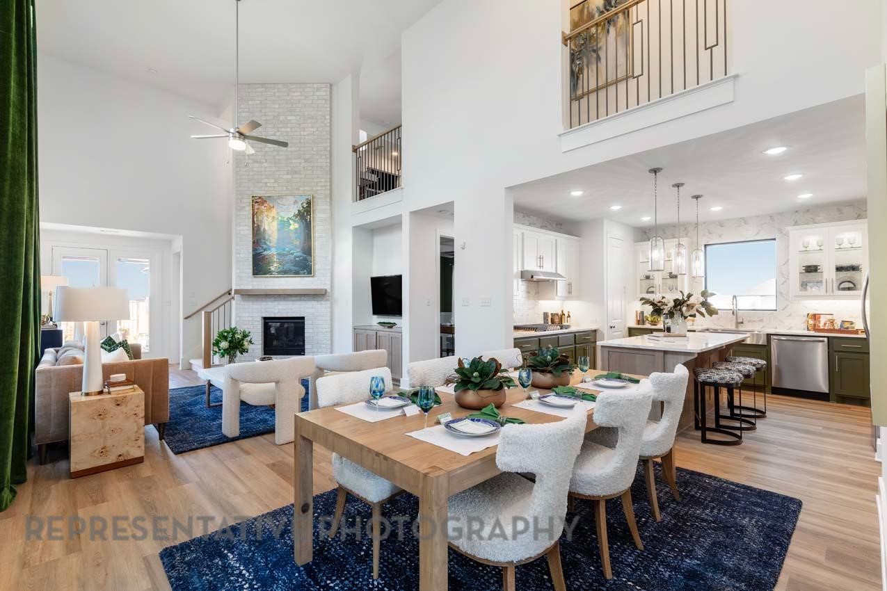 5411 Bonfire Alley Manvel, TX 77578 - Photo 6 of 21 a view of a dining room and livingroom with furniture wooden floor a rug a fireplace and a chandelier