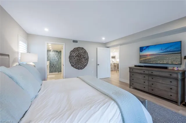 a spacious bedroom with a bed and a television