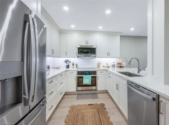 a kitchen with granite countertop a refrigerator stove top oven and sink