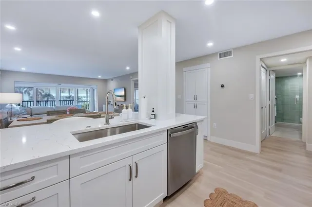 a view with double vanity sink a mirror and a refrigerator