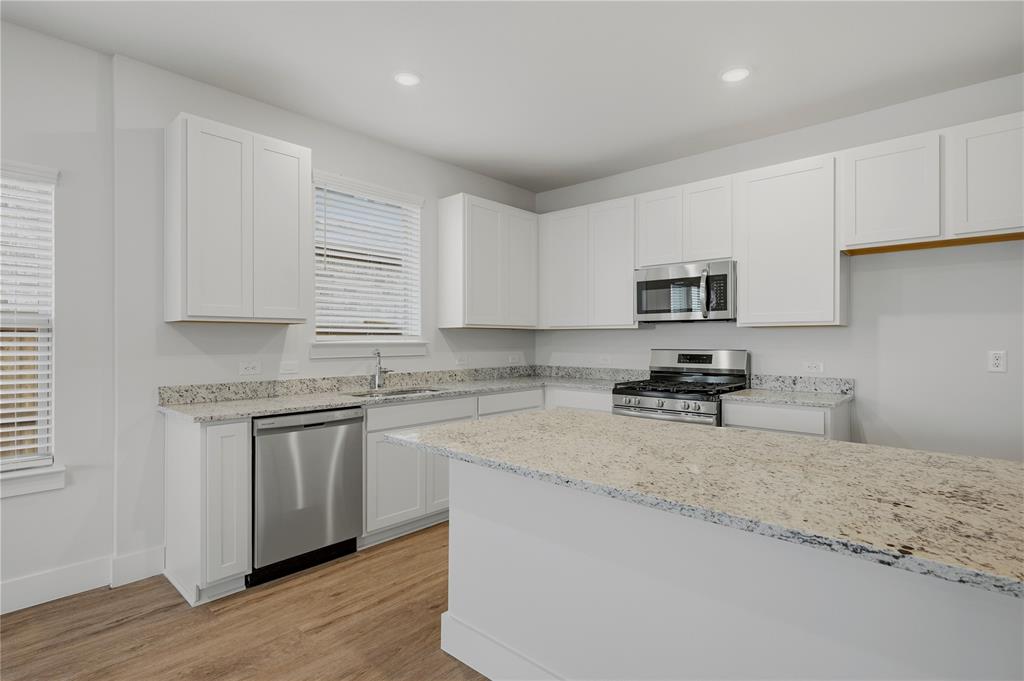 1346 Chisos Way Forney, TX 75126 - Photo 12 of 40 a kitchen with granite countertop white cabinets sink and stainless steel appliances