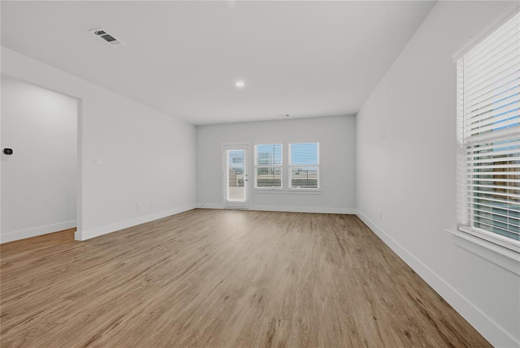 1346 Chisos Way Forney, TX 75126 - Photo 5 of 40 an empty room with wooden floor and windows