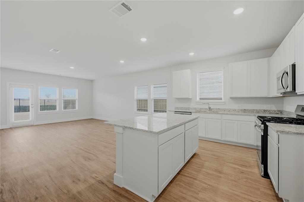 1346 Chisos Way Forney, TX 75126 - Photo 10 of 40 a kitchen with stainless steel appliances granite countertop a stove and a sink