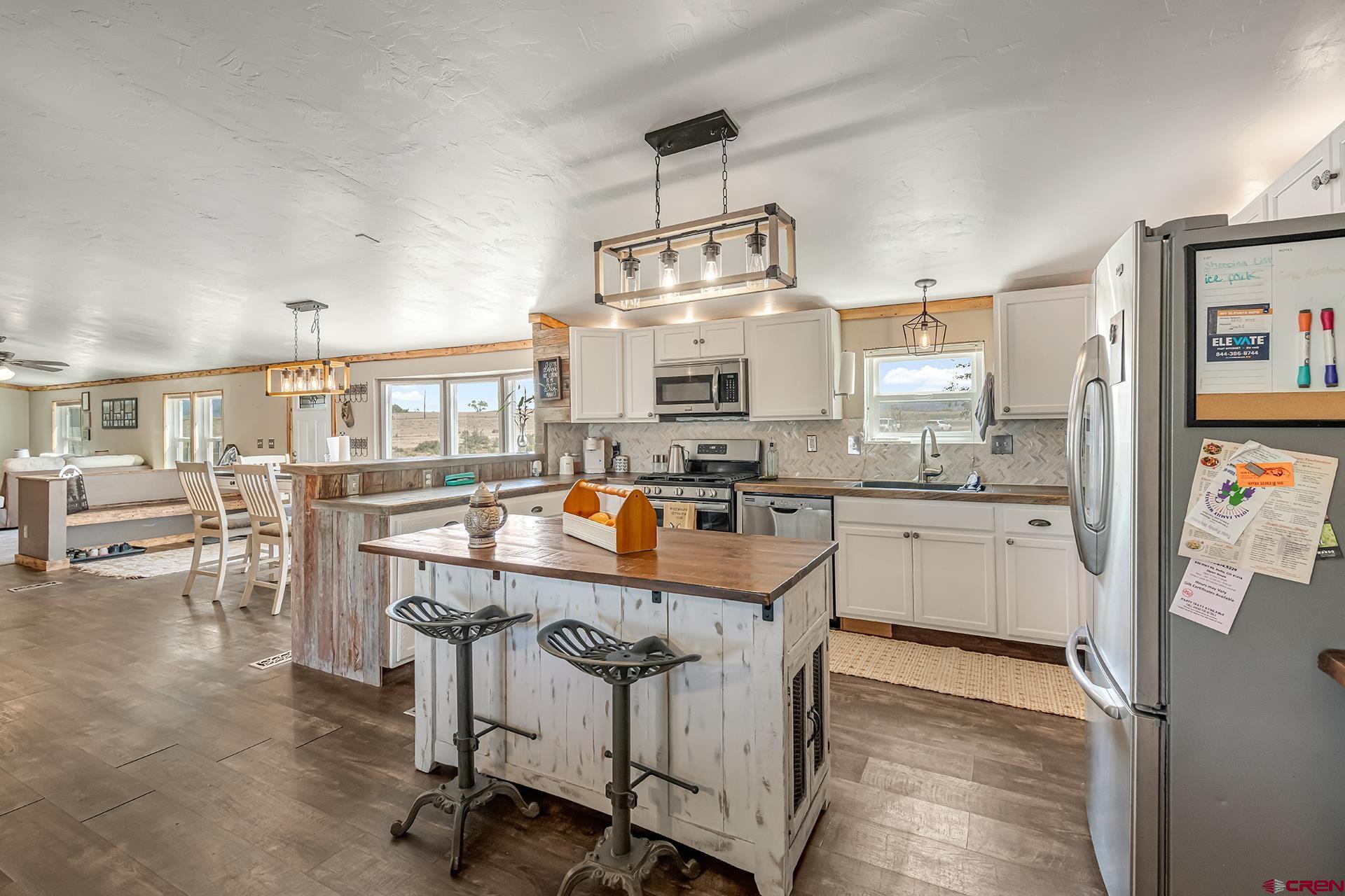 2787 2100th Road Delta, CO 81416 - Photo 16 of 40 a kitchen with kitchen island a large counter top space appliances and cabinets