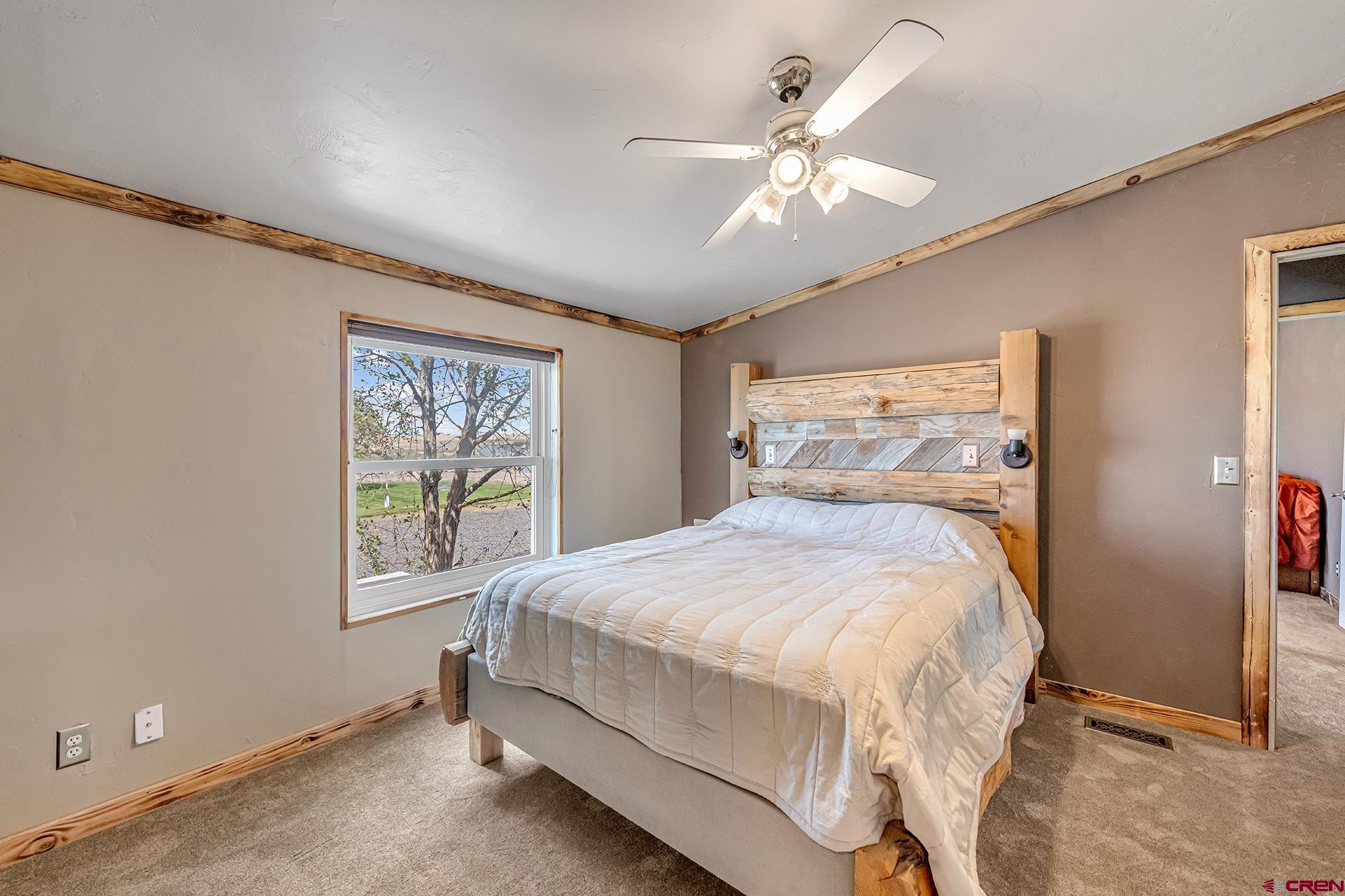 2787 2100th Road Delta, CO 81416 - Photo 20 of 40 a bedroom with a large bed and a chandelier