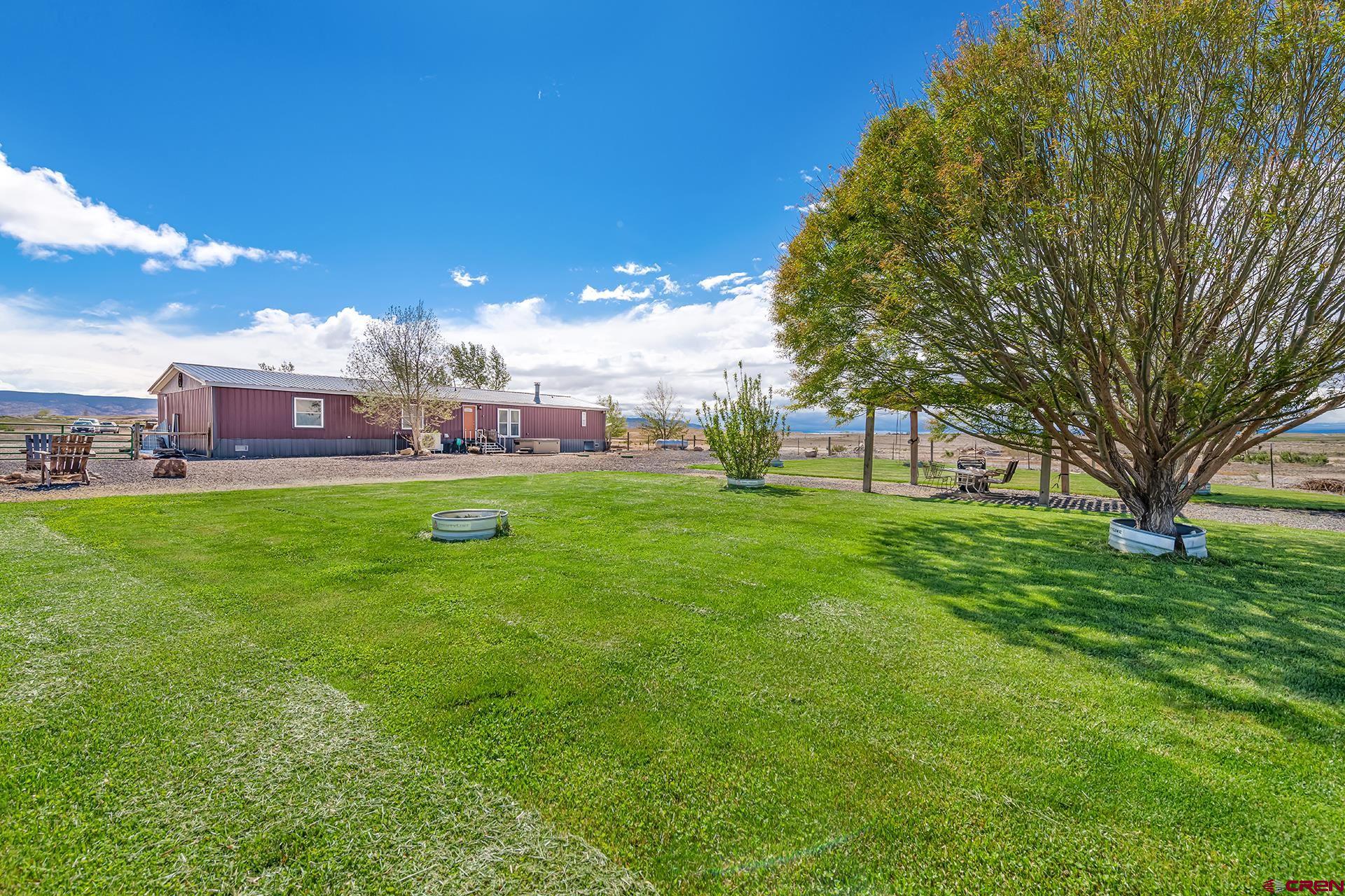 2787 2100th Road Delta, CO 81416 - Photo 38 of 40 a view of a big yard with a house in the background