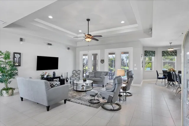 a living room with furniture a flat screen tv and a large window
