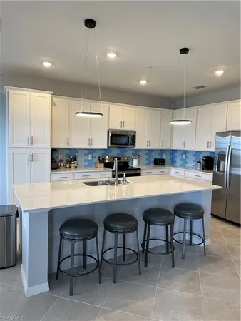 a kitchen with refrigerator and chairs