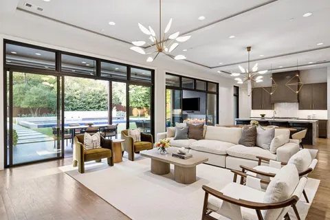 a dining room with furniture a chandelier and large windows