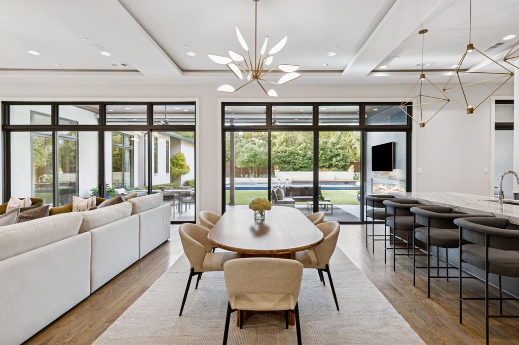 4447 Taos Road Dallas, TX 75209 - Photo 12 of 38 a dining room with furniture a chandelier and large windows
