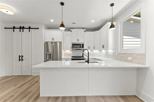 a kitchen with kitchen island a counter top space stainless steel appliances and a window