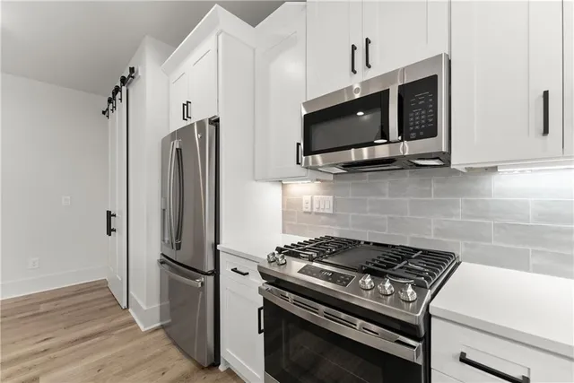 a kitchen with stainless steel appliances a stove a microwave and a refrigerator