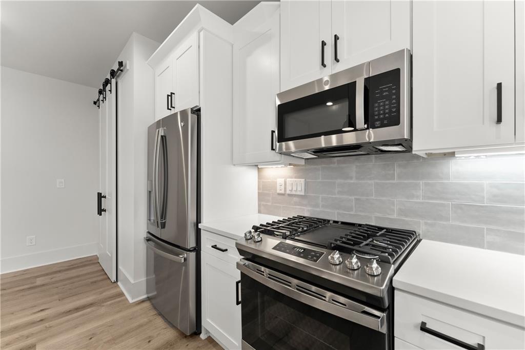 372 Forrest Avenue Gainesville, GA 30501 - Photo 15 of 29 a kitchen with stainless steel appliances a stove a microwave and a refrigerator
