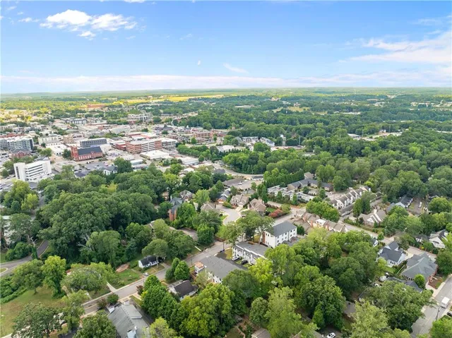 an aerial view of residential houses with outdoor space and trees
