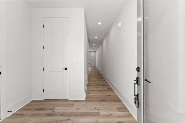 a view of a hallway with wooden floor and staircase