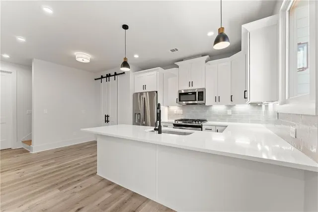 a kitchen with stainless steel appliances granite countertop a sink a stove and a refrigerator