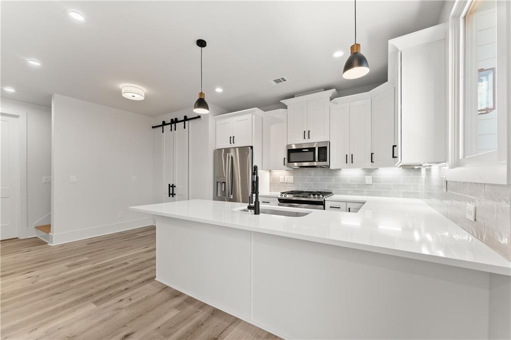 372 Forrest Avenue Gainesville, GA 30501 - Photo 10 of 29 a kitchen with stainless steel appliances granite countertop a sink a stove and a refrigerator