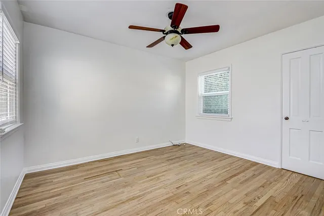 a view of a room with wooden floor and ceiling fan