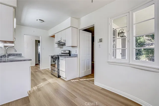 a kitchen with granite countertop a sink stove and refrigerator