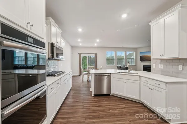 a large kitchen with stainless steel appliances granite countertop a stove and a sink