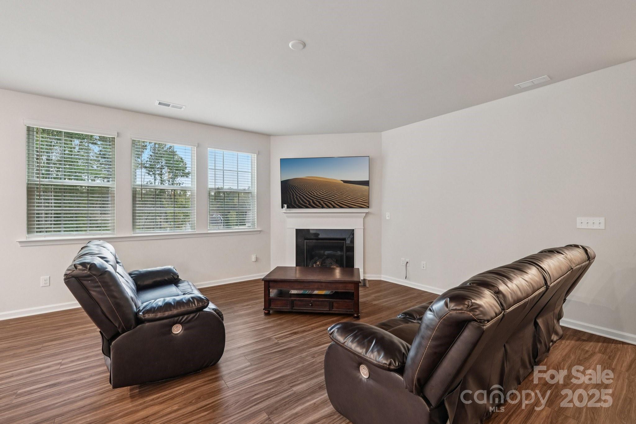 299 Hamptons Cove Road Troutman, NC 28166 - Photo 14 of 40 a living room with furniture a fireplace and a flat screen tv
