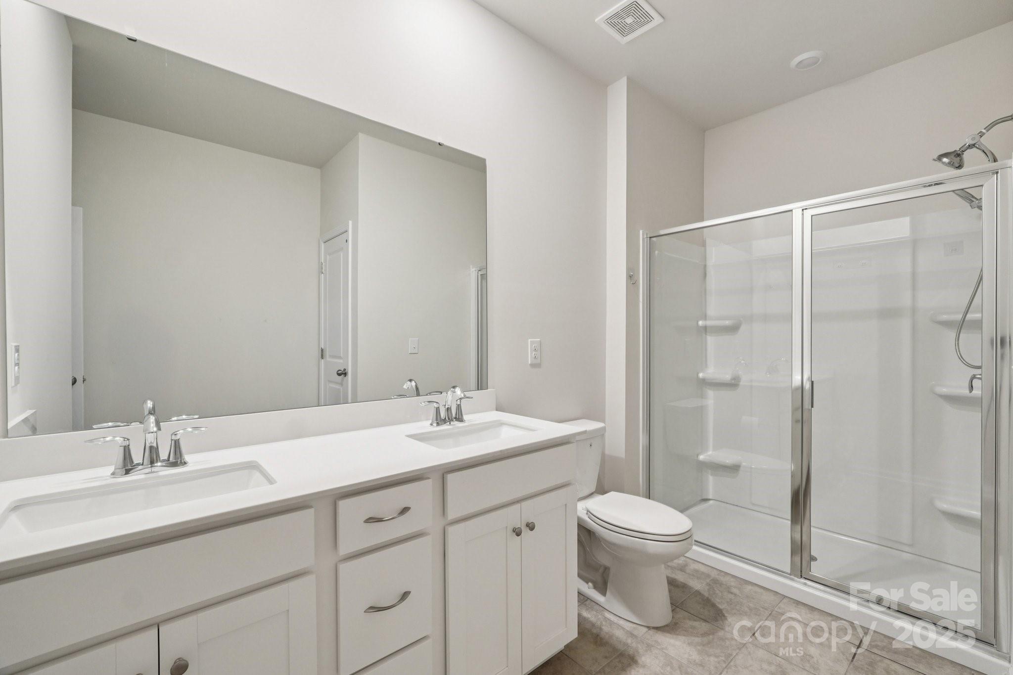299 Hamptons Cove Road Troutman, NC 28166 - Photo 18 of 40 a bathroom with a granite countertop sink a toilet and shower