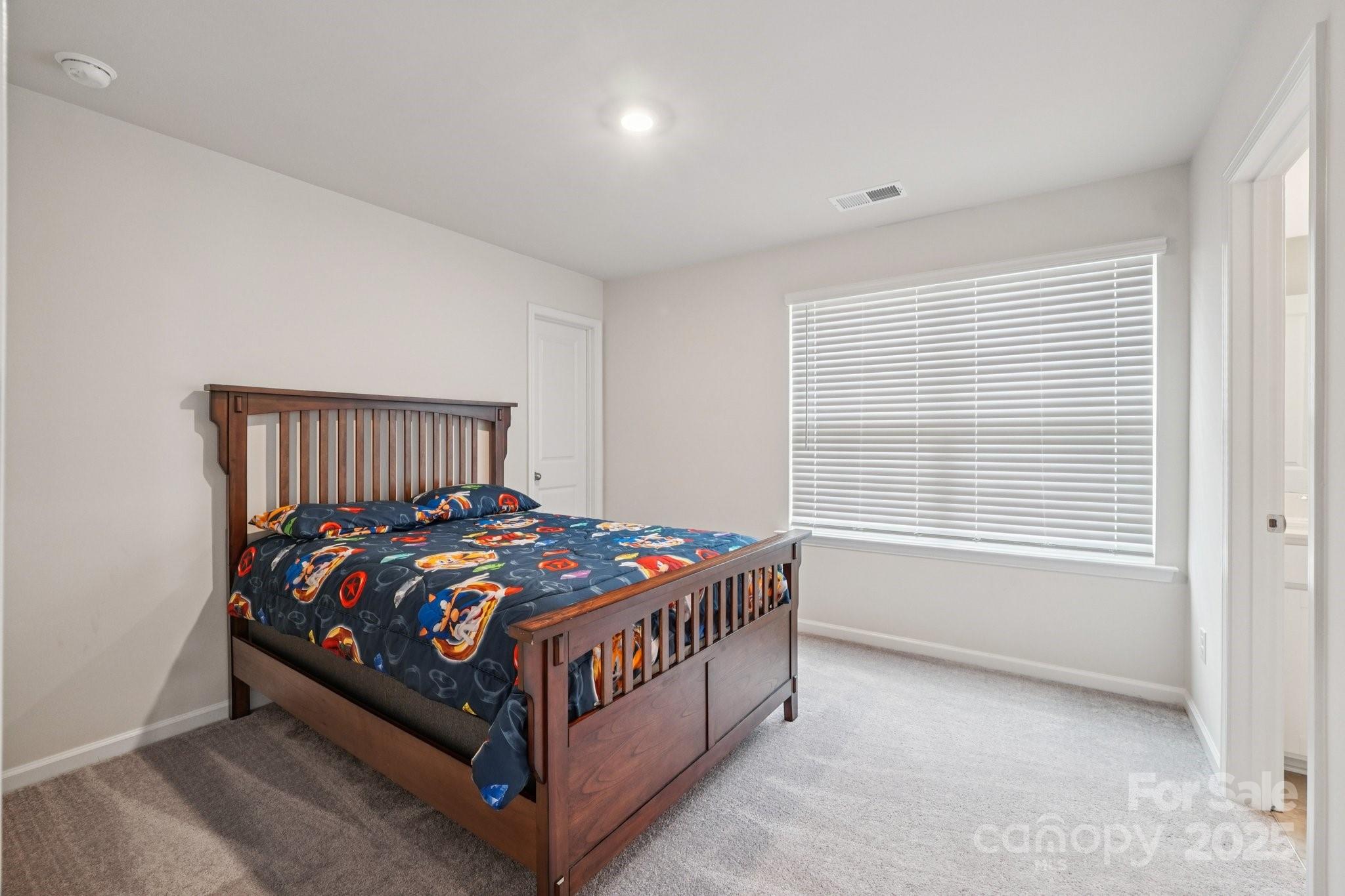 299 Hamptons Cove Road Troutman, NC 28166 - Photo 21 of 40 a bedroom with a bed and window