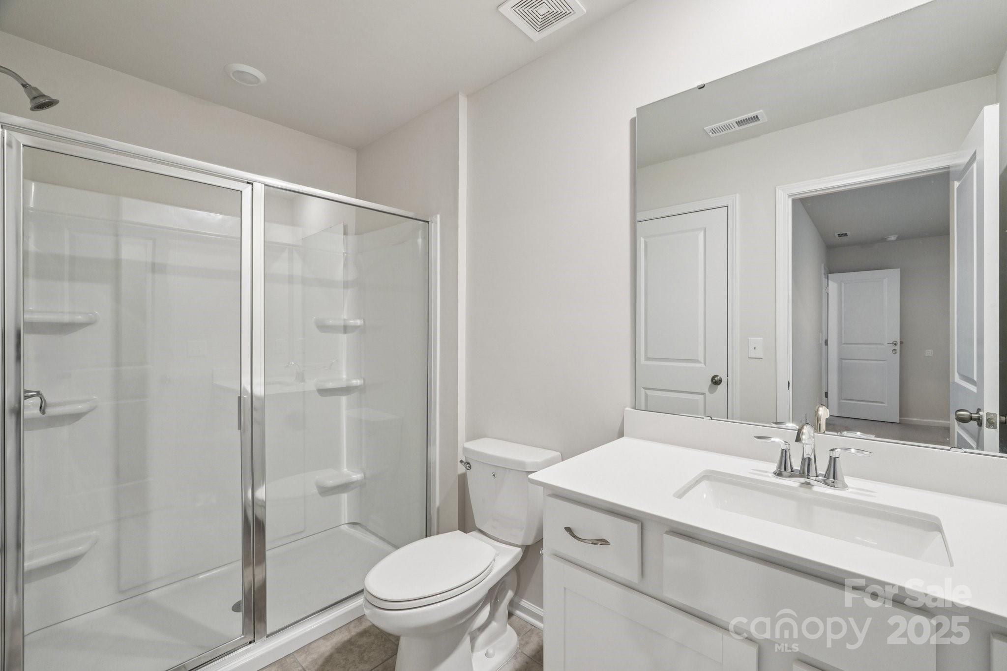 299 Hamptons Cove Road Troutman, NC 28166 - Photo 25 of 40 a bathroom with a sink toilet vanity and shower