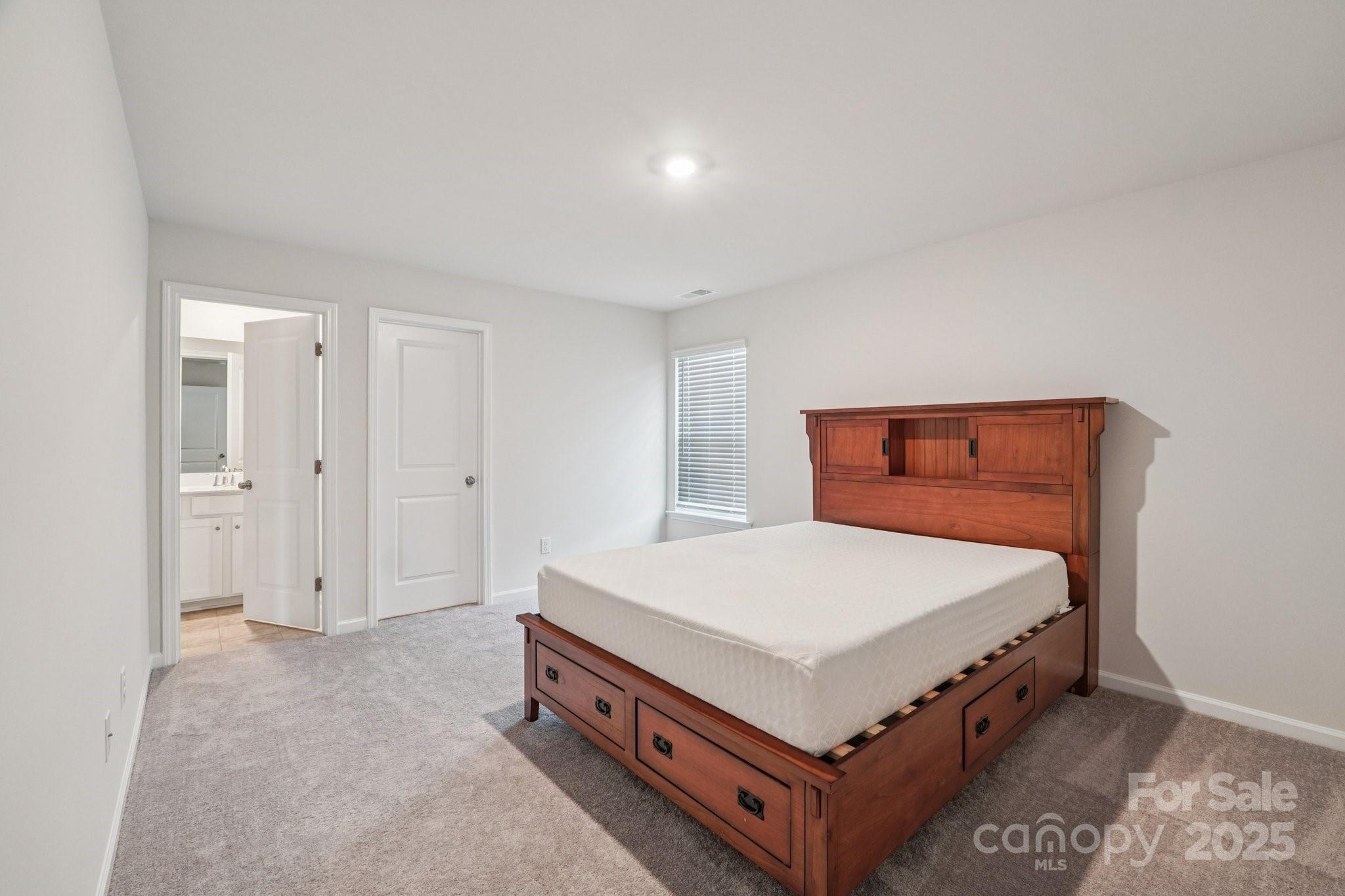 299 Hamptons Cove Road Troutman, NC 28166 - Photo 35 of 40 a room with a bed and a table
