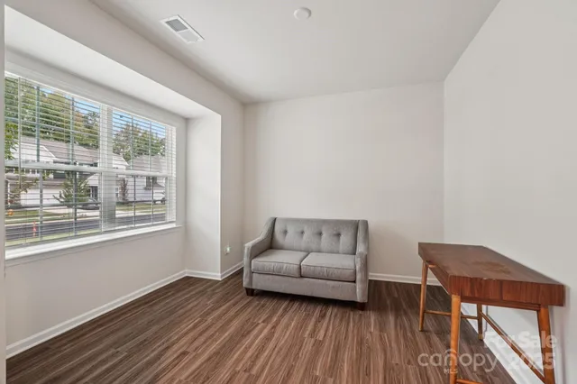 a large white kitchen with kitchen island a sink wooden floor and stainless steel appliances