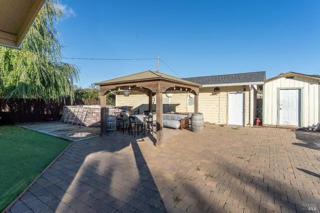 a patio with a table and chairs under an umbrella