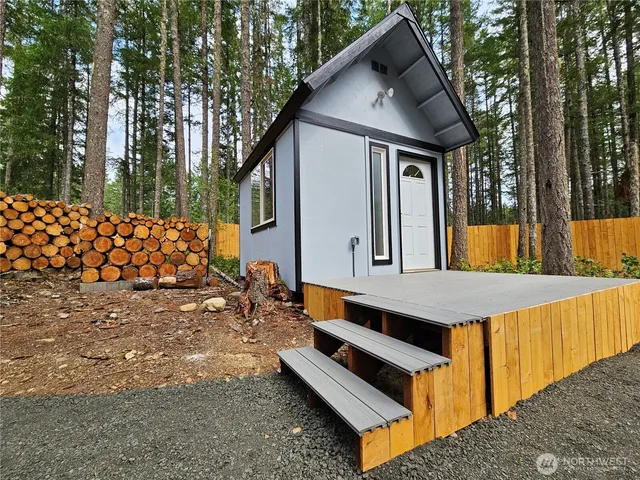 a front view of a house with large trees
