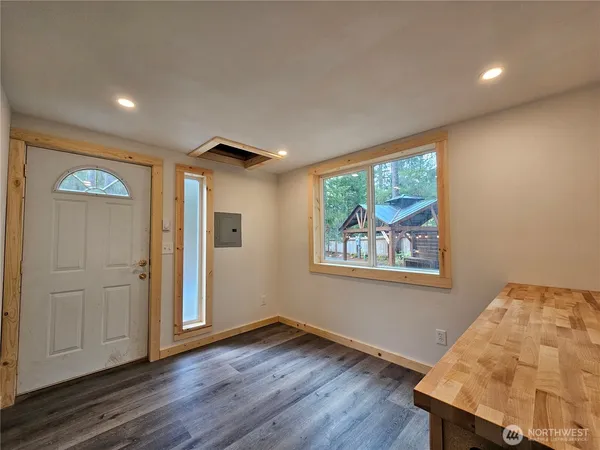a view of an empty room with wooden floor and a window