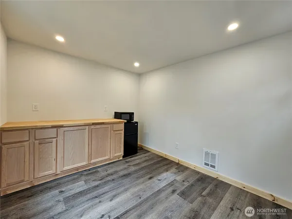 a view of an empty room with wooden floor