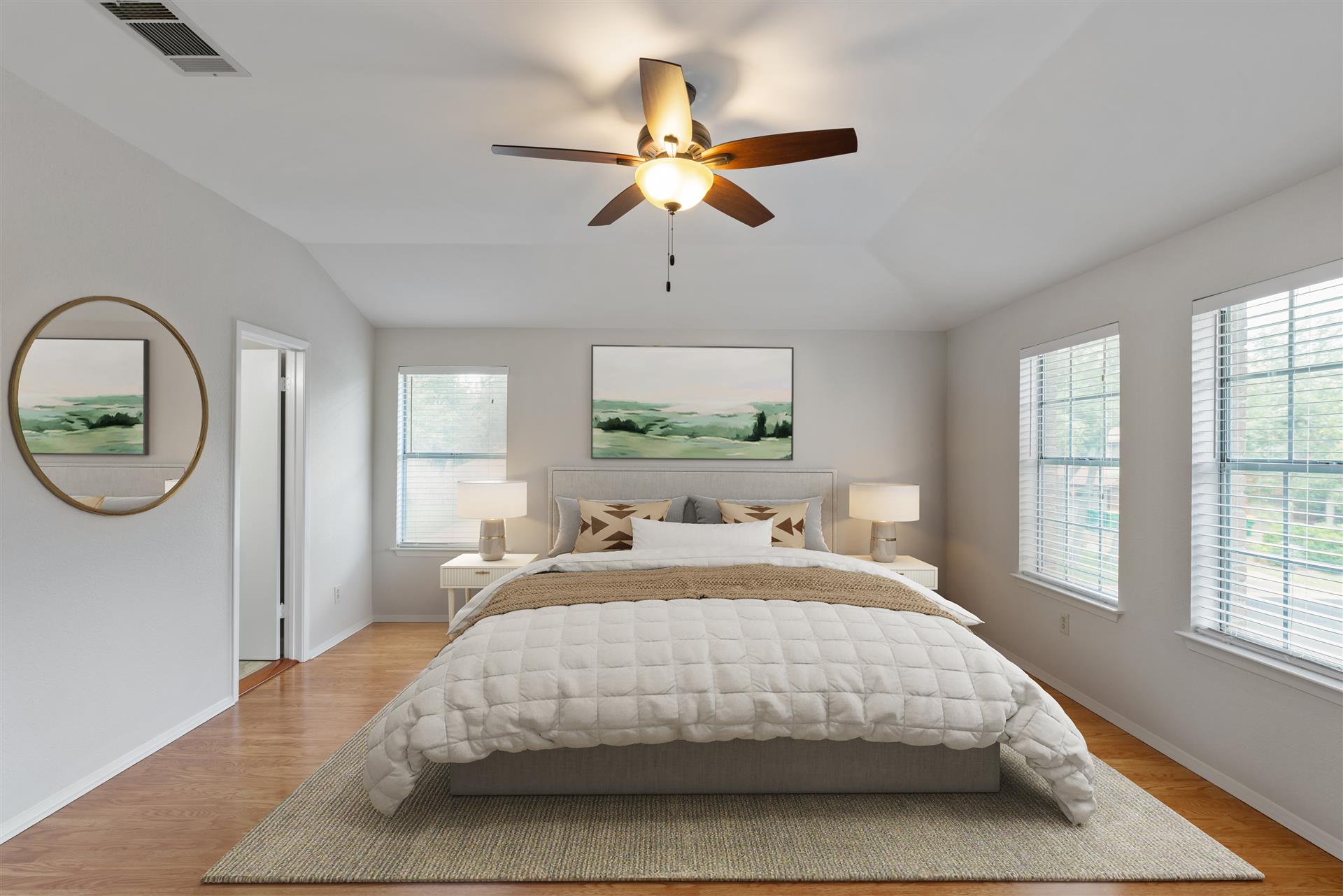 1710 Persimmon Road Cedar Park, TX 78613 - Photo 8 of 33 Well-lit sleeping primary bedroom with a ceiling fan, vaulted ceiling, abundant natural light from multiple windows, and an ensuite spa bathroom.