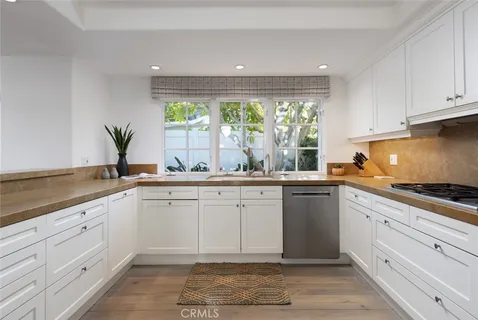 a kitchen with white cabinets and a window