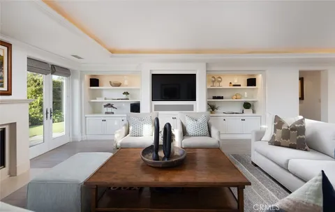 a living room with furniture a flat screen tv and a view of kitchen