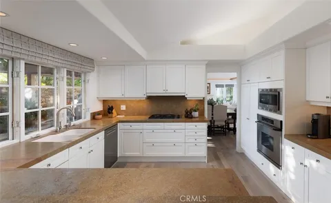 a large kitchen with stainless steel appliances granite countertop a stove a sink and a refrigerator