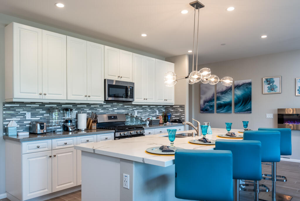 50715 Monterey Cyn Drive Indio, CA 92201 - Photo 15 of 43 a kitchen with stainless steel appliances kitchen island granite countertop a sink a stove a oven a dining table and chairs
