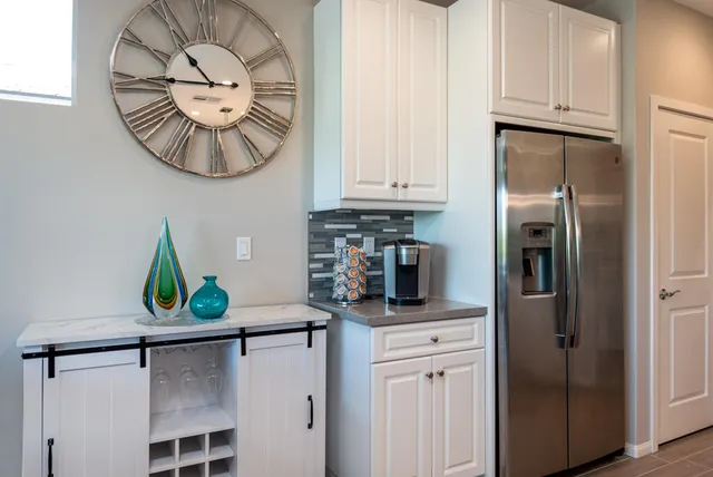 a kitchen with stainless steel appliances granite countertop a refrigerator a stove and a sink