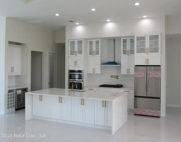a kitchen with stainless steel appliances kitchen island granite countertop a refrigerator and a stove