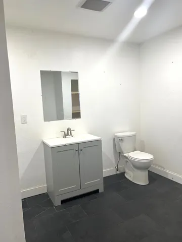 a white toilet sitting next to a bathroom sink