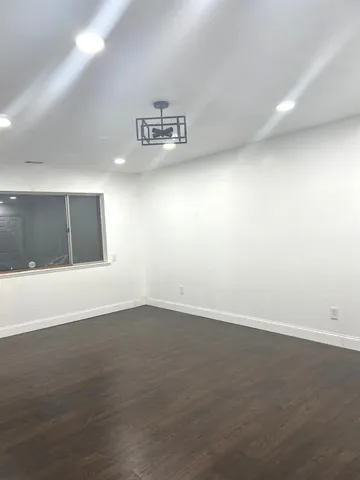 an empty room with windows and ceiling fan